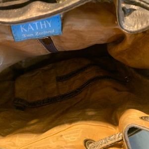 Bronze leather back pack w studded front and side pockets with pull closure